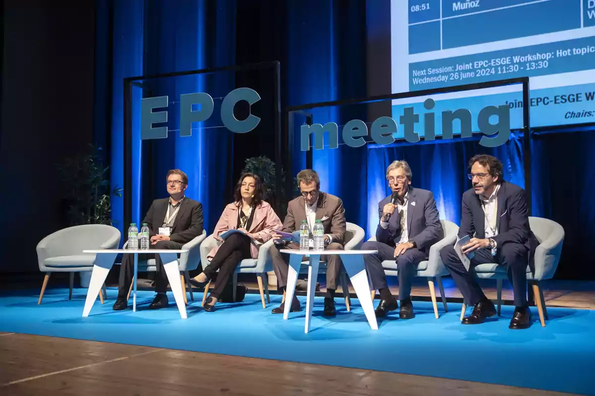 Cinco personas sentadas en un escenario durante una conferencia con el letrero "EPC meeting" detrás de ellos.