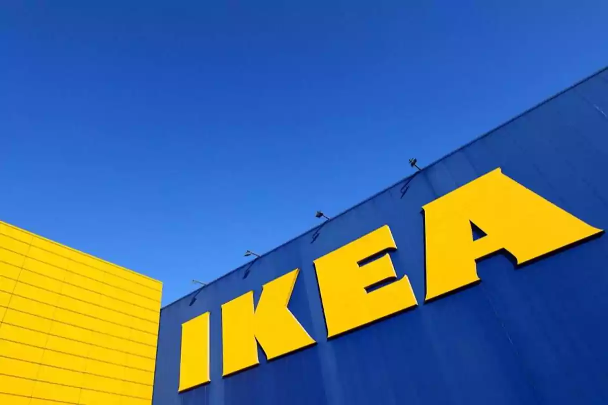 Fachada de una tienda IKEA con letras amarillas sobre fondo azul y cielo despejado.