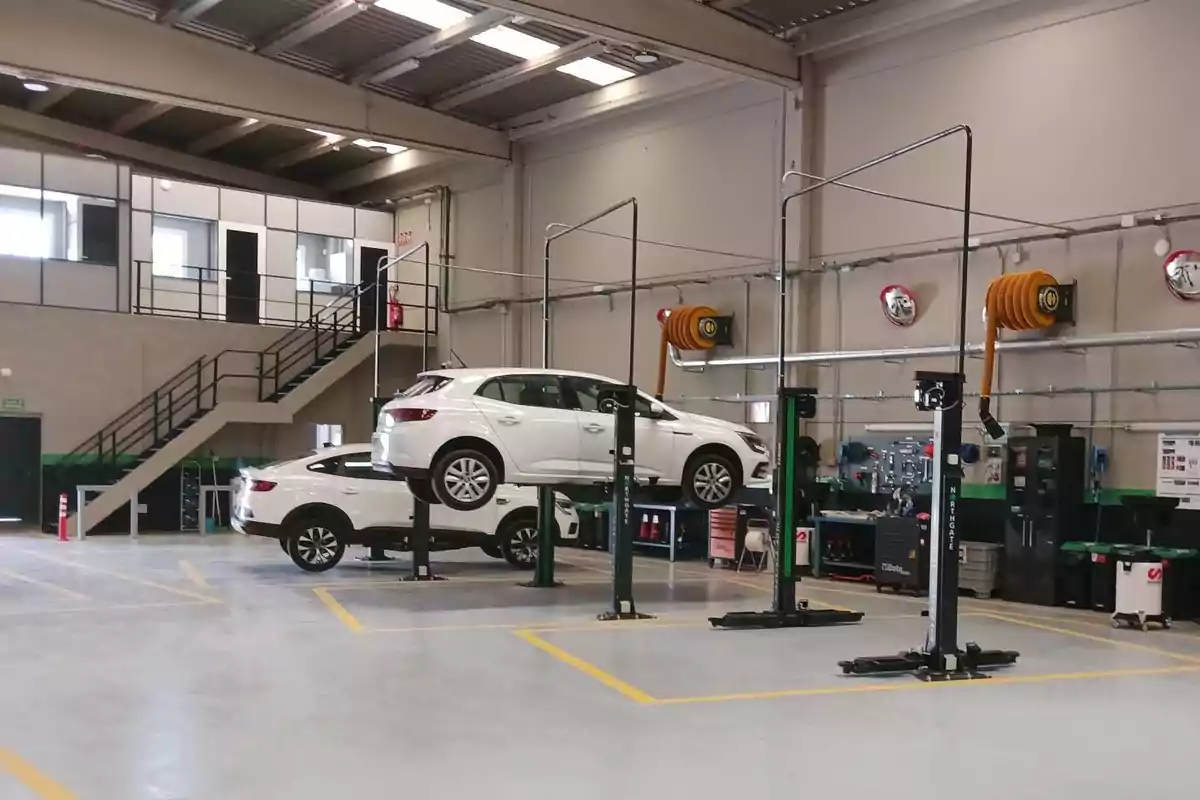 Taller mecánico moderno con autos blancos en elevadores y área de trabajo organizada
