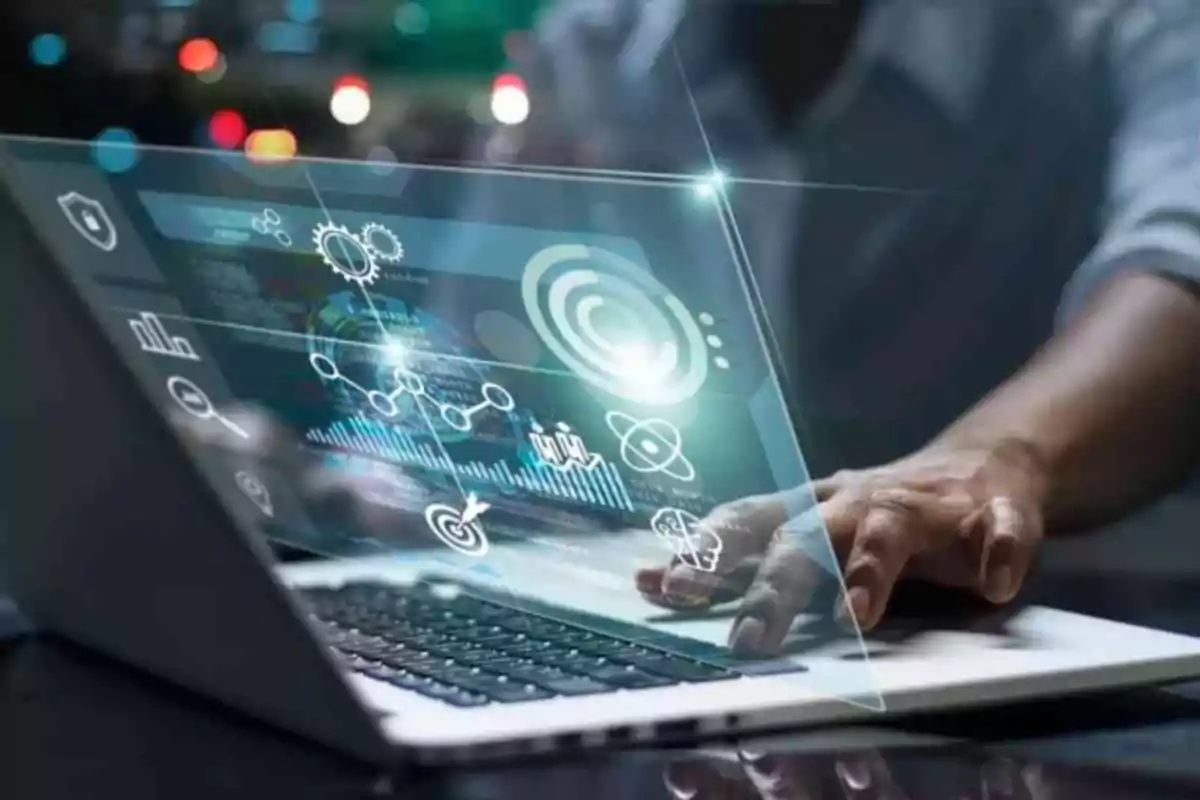Persona utilizando una laptop con gráficos y elementos digitales futuristas proyectados sobre la pantalla