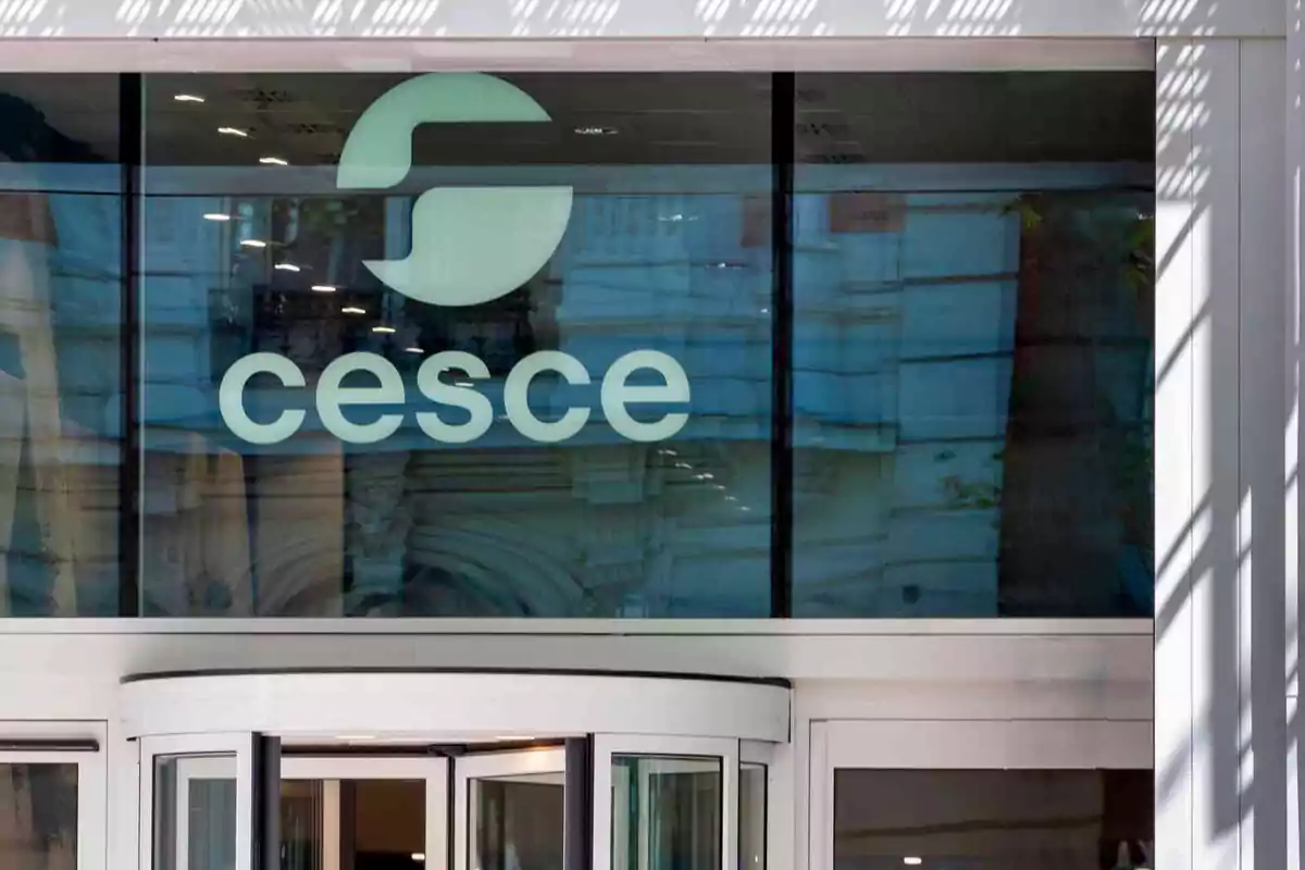 Entrada principal de un edificio con el logo y nombre de la empresa cesce en el cristal superior