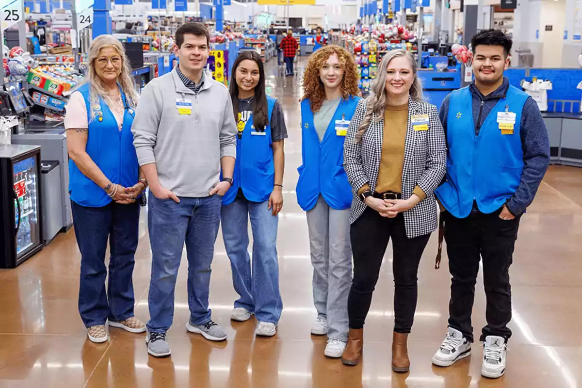 Grupo de empleados de supermercado posando juntos en el área de cajas