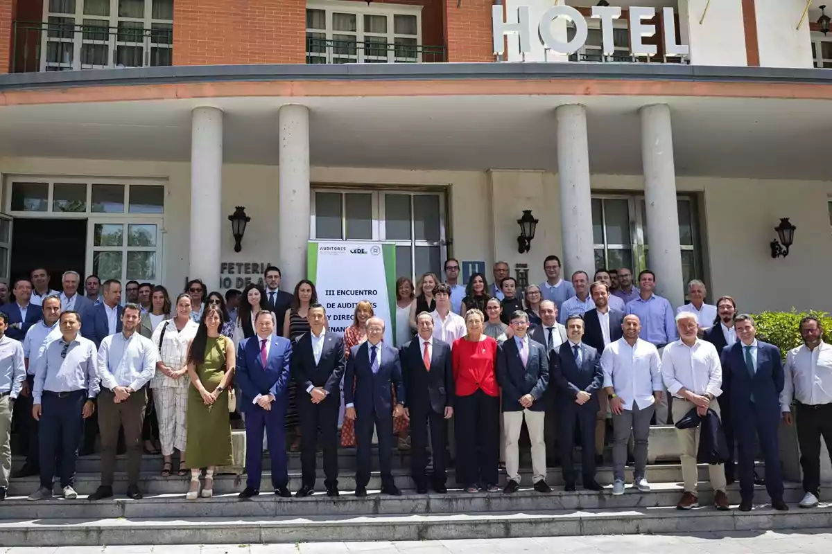Un grupo numeroso de personas posando para una foto en la entrada de un hotel durante un evento profesional