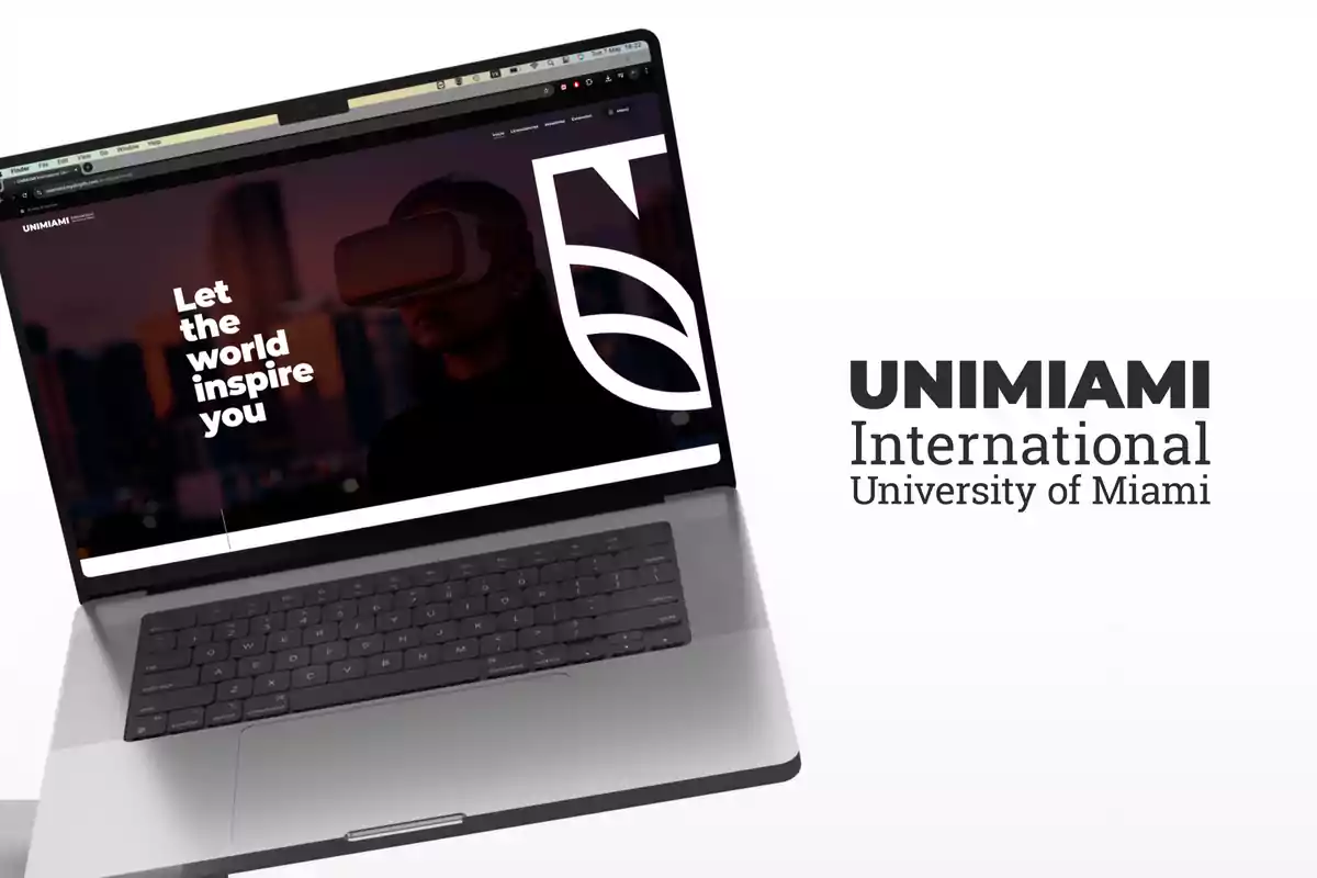 Laptop con la página web de una universidad mostrando a una persona usando gafas de realidad virtual y el texto Let the world inspire you junto al logotipo de UNIMIAMI International University of Miami sobre fondo blanco