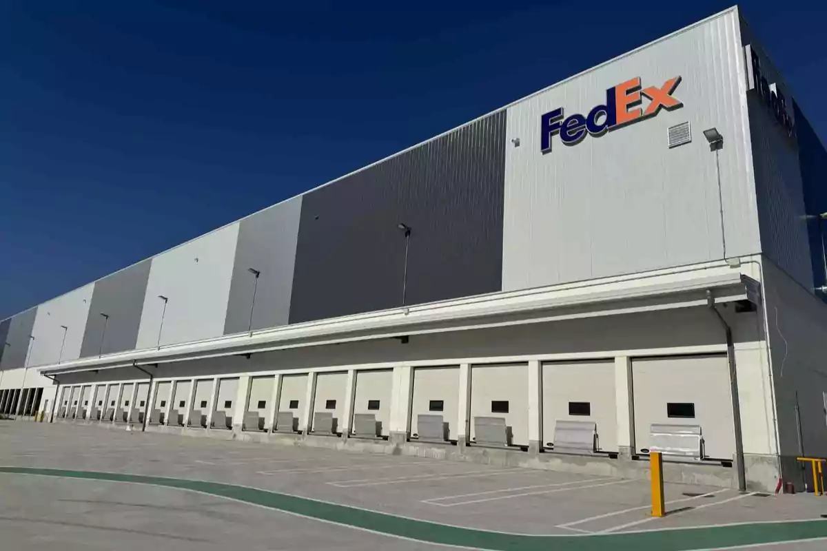 Edificio industrial de FedEx con varias rampas de carga y descarga en un día soleado