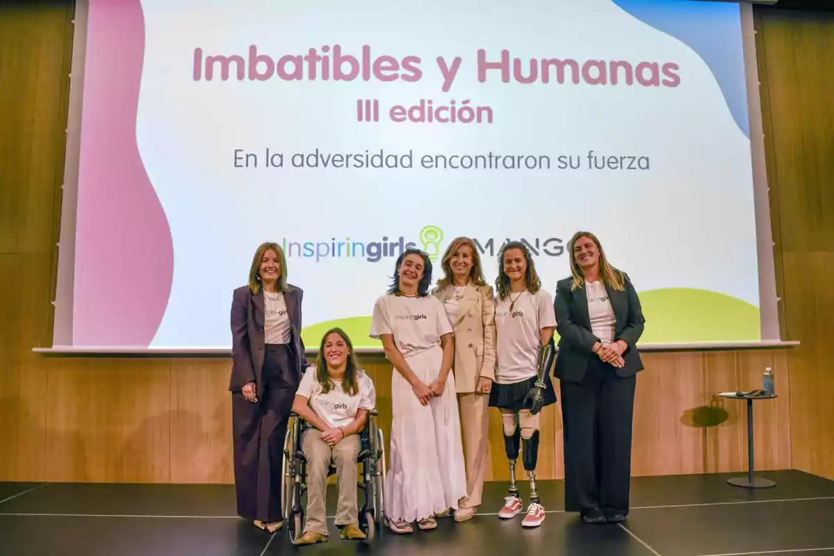 Seis mujeres posan sonrientes en un escenario frente a una pantalla que muestra el título Imbatibles y Humanas III edición y el lema En la adversidad encontraron su fuerza, durante un evento de Inspiring Girls y Mango