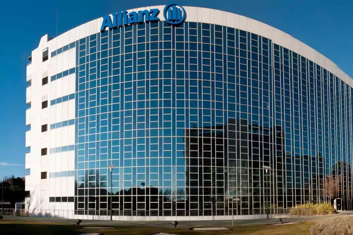 Edificio moderno de oficinas con fachada de vidrio y el logotipo de Allianz en la parte superior bajo un cielo despejado