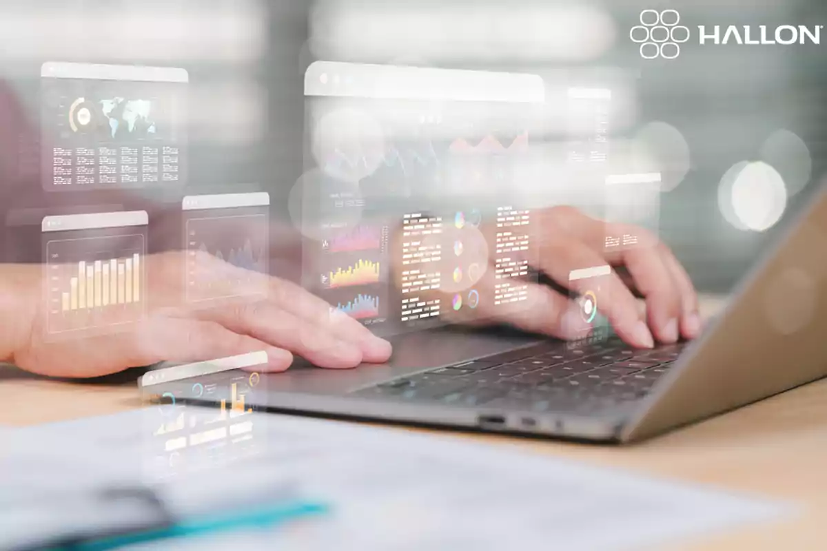 Persona usando una laptop con gráficos y datos digitales superpuestos en la pantalla