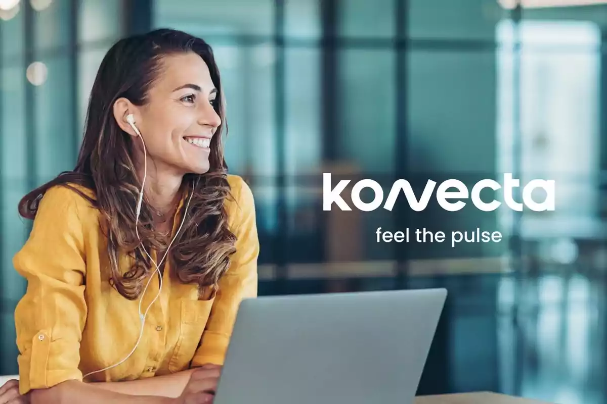 Mujer sonriente con auriculares trabajando en una laptop con el logo de Konecta y el eslogan feel the pulse al fondo