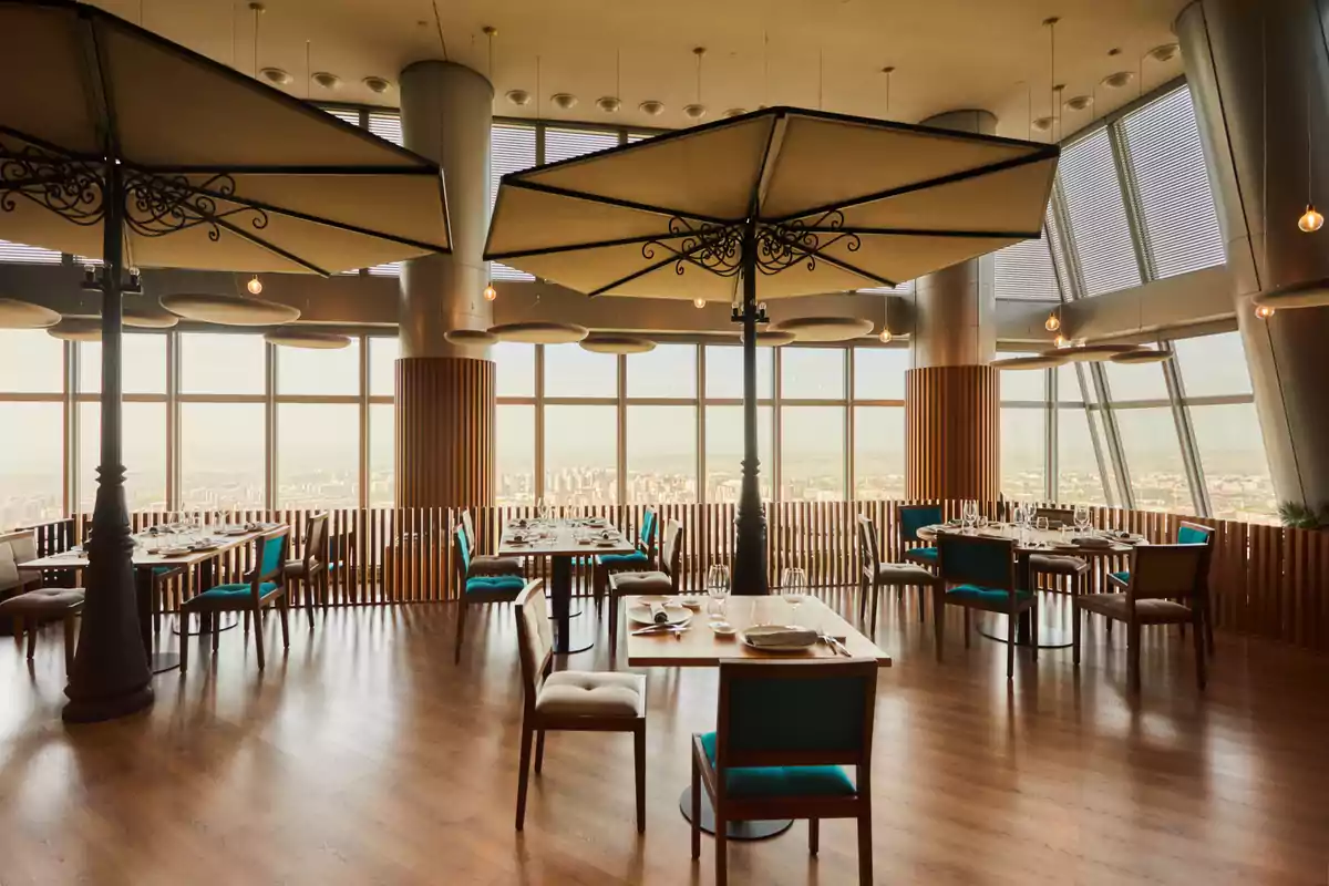 Restaurante elegante con grandes ventanales, mesas bien puestas y vista panorámica de la ciudad Restaurante elegante con grandes ventanales, mesas bien puestas y vista panorámica de la ciudad