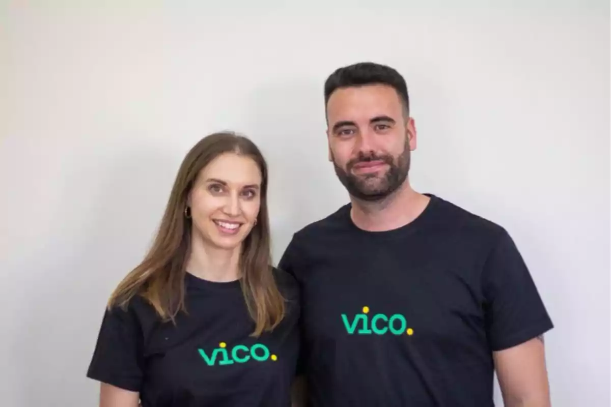 Dos personas sonrientes con camisetas negras que tienen el logo de vico sobre un fondo blanco.