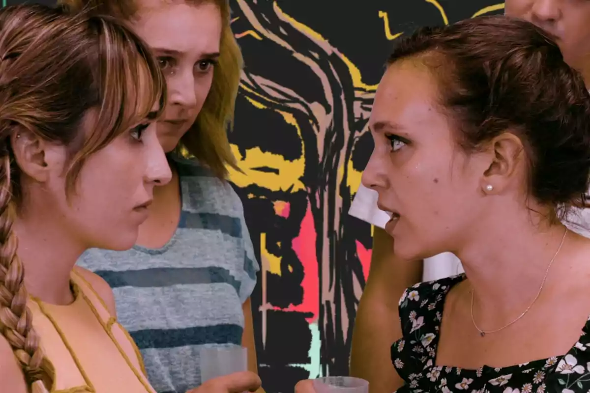 Dos mujeres se miran fijamente con expresiones serias mientras otras dos personas observan la situación en un ambiente tenso con un fondo colorido y abstracto