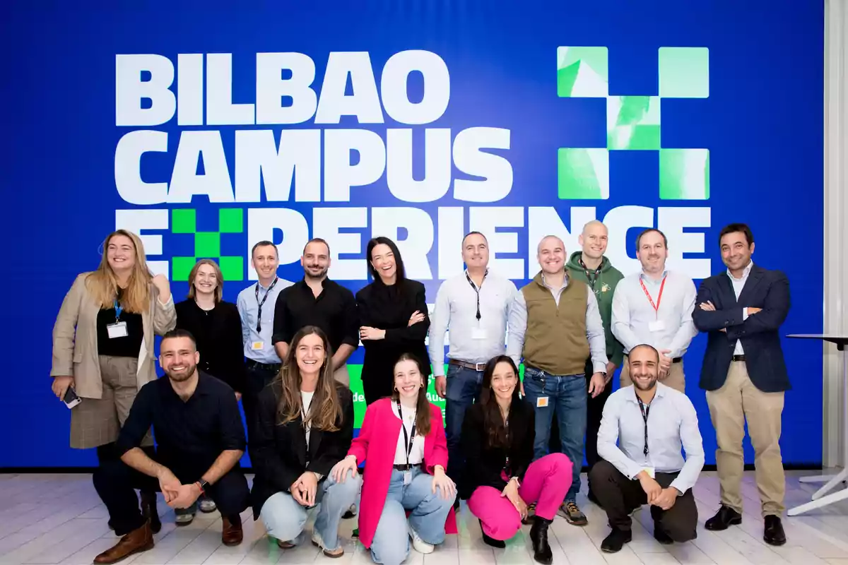 Grupo de personas posando sonrientes frente a un fondo azul con el texto Bilbao Campus Experience