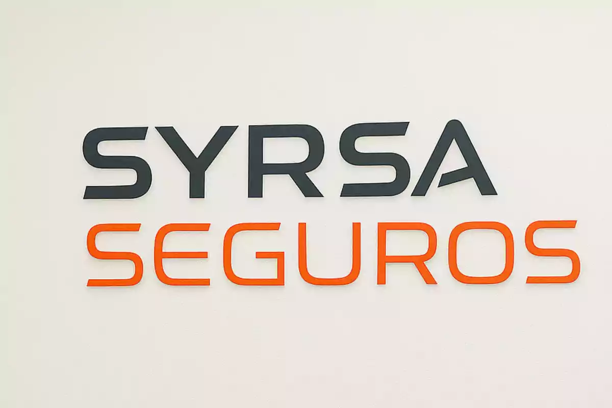 Letrero en una pared con las palabras SYRSA en letras negras y SEGUROS en letras naranjas