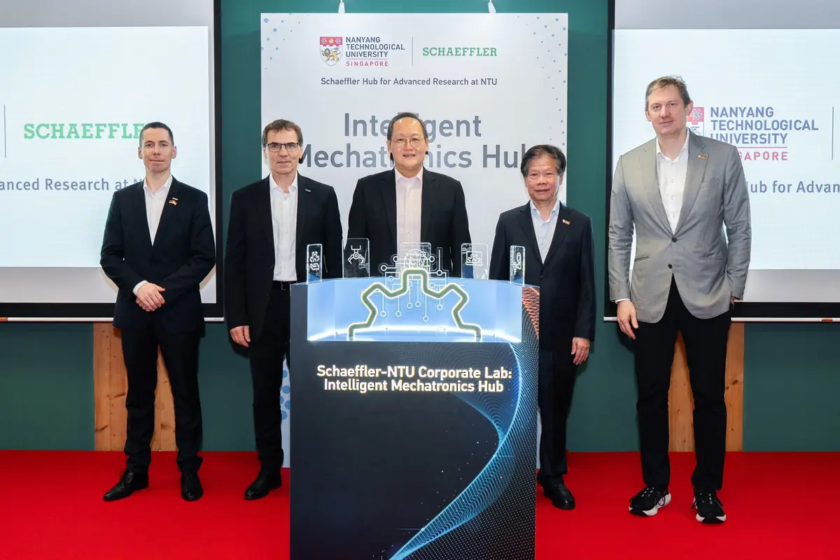Cinco hombres de negocios posan frente a un atril iluminado con el texto Schaeffler NTU Corporate Lab Intelligent Mechatronics Hub durante un evento oficial en la Universidad Tecnológica de Nanyang