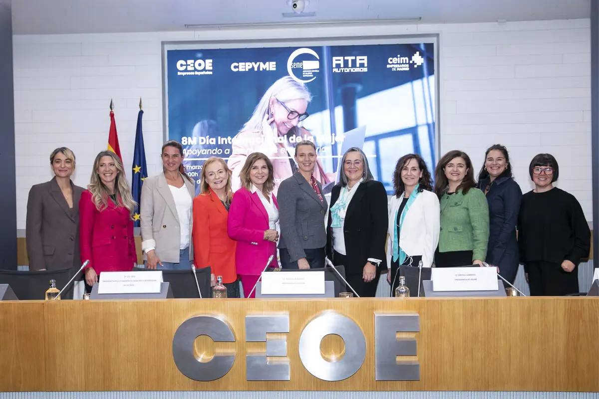 Grupo de mujeres directivas posando sonrientes frente a una mesa de conferencias en un acto institucional por el Día Internacional de la Mujer en la sede de la CEOE