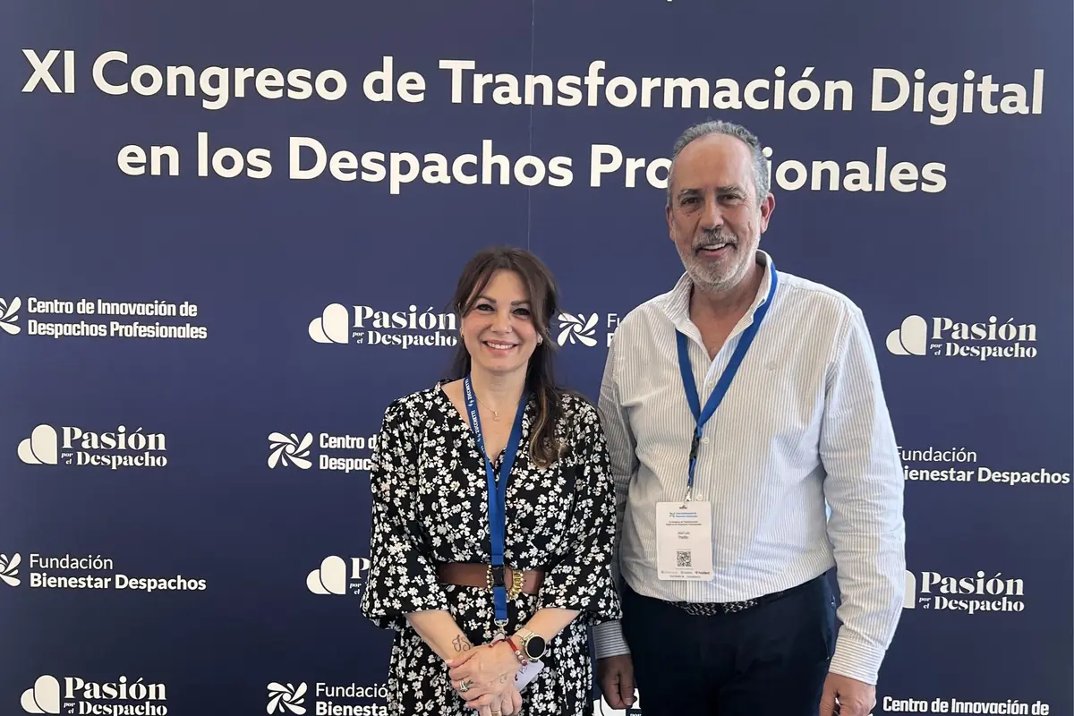 Dos personas con acreditación posan sonrientes frente a un panel del XI Congreso de Transformación Digital en los Despachos Profesionales Dos personas con acreditación posan sonrientes frente a un panel del XI Congreso de Transformación Digital en los Despachos Profesionales