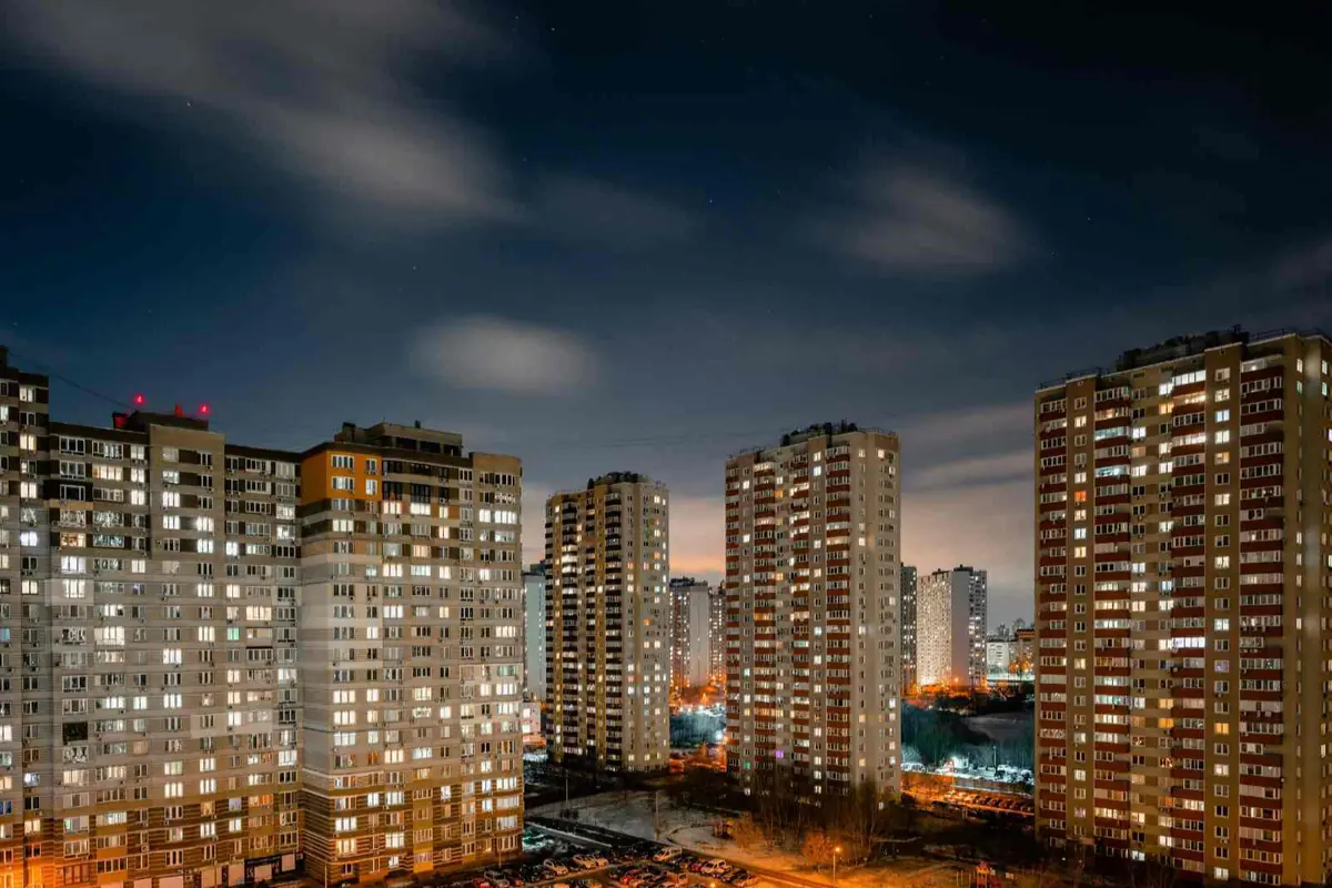 Panorama nocturno de varios edificios de apartamentos altos con muchas ventanas iluminadas y calles con luces naranjas en una ciudad moderna Panorama nocturno de varios edificios de apartamentos altos con muchas ventanas iluminadas y calles con luces naranjas en una ciudad moderna