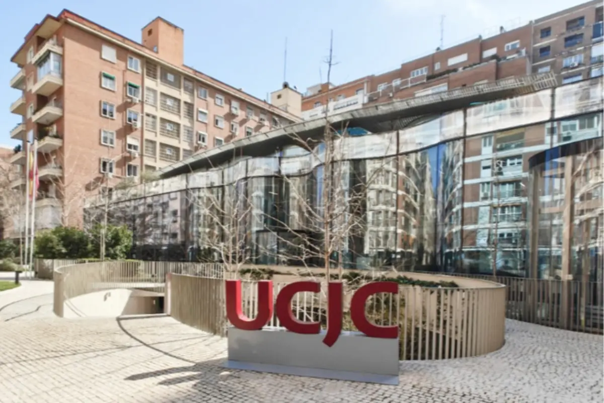 Entrada moderna del campus urbano de la UCJC con fachada acristalada y edificios residenciales al fondo Entrada moderna del campus urbano de la UCJC con fachada acristalada y edificios residenciales al fondo