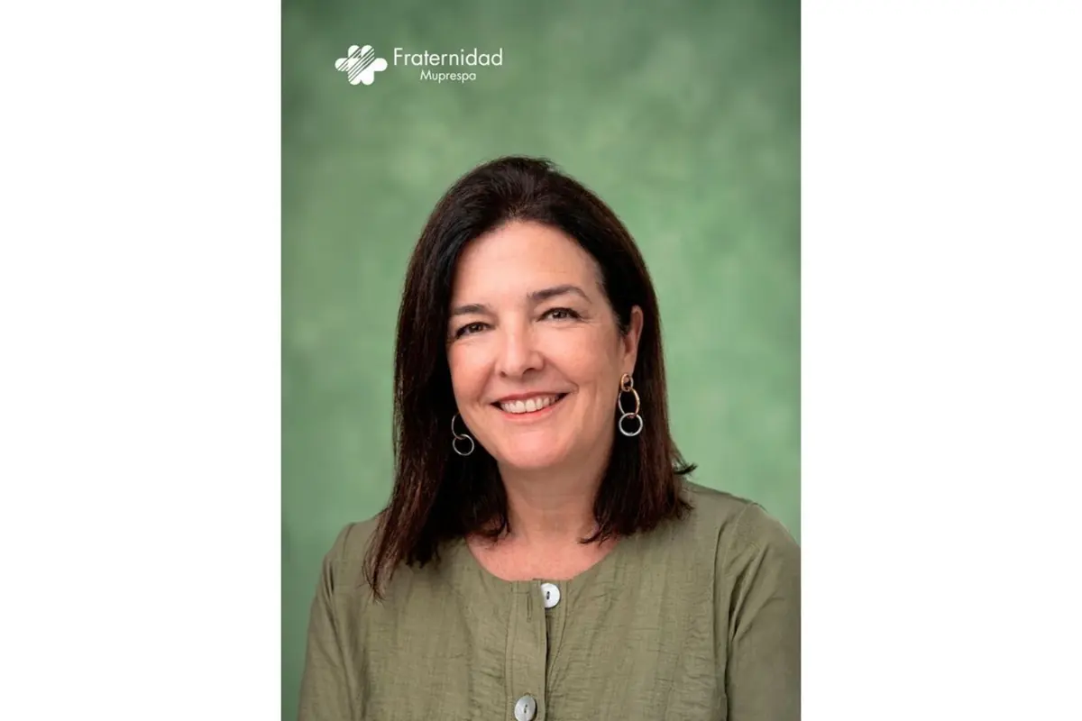 Retrato de una mujer de mediana edad sonriendo con blusa verde y pendientes dorados sobre fondo verde con el logotipo de Fraternidad Muprespa en la parte superior izquierda
