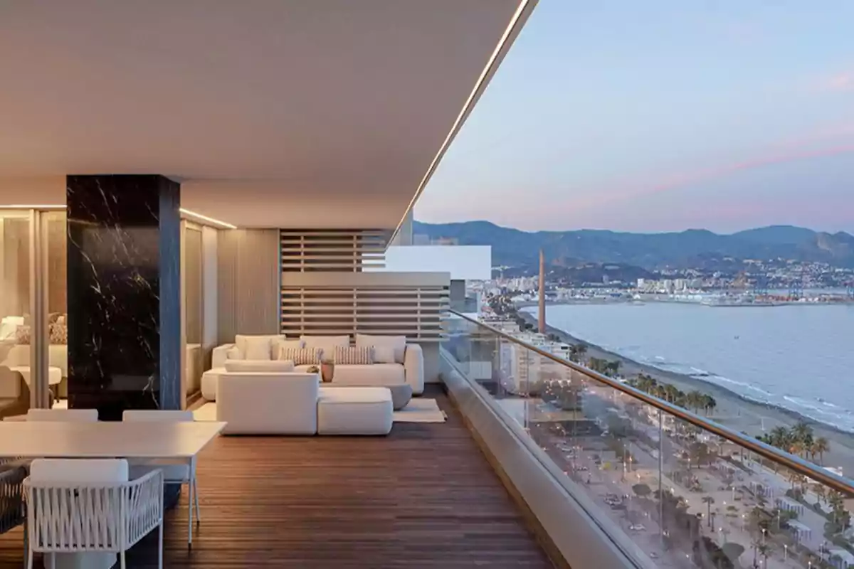 Terraza moderna con muebles blancos y vista panorámica al mar y la ciudad.