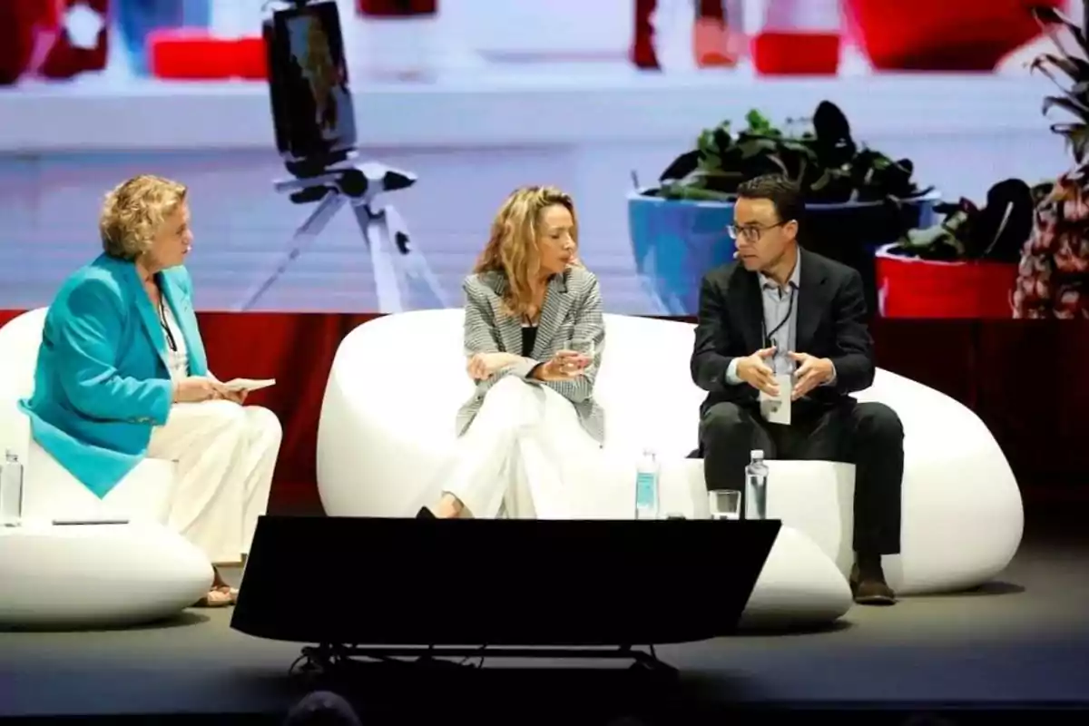 Tres personas sentadas en un sofá y hablando