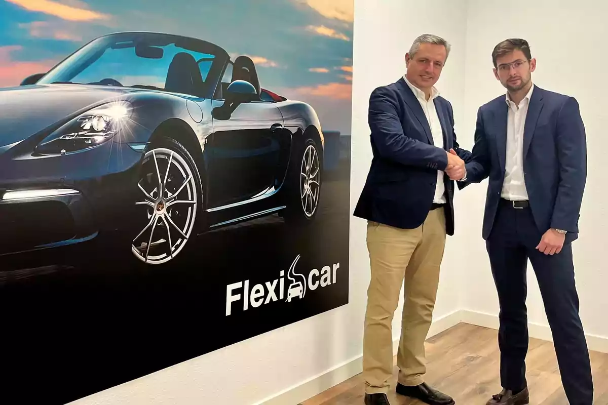 Dos hombres de traje dándose la mano junto a un cartel de un coche deportivo con el logo de Flexicar.