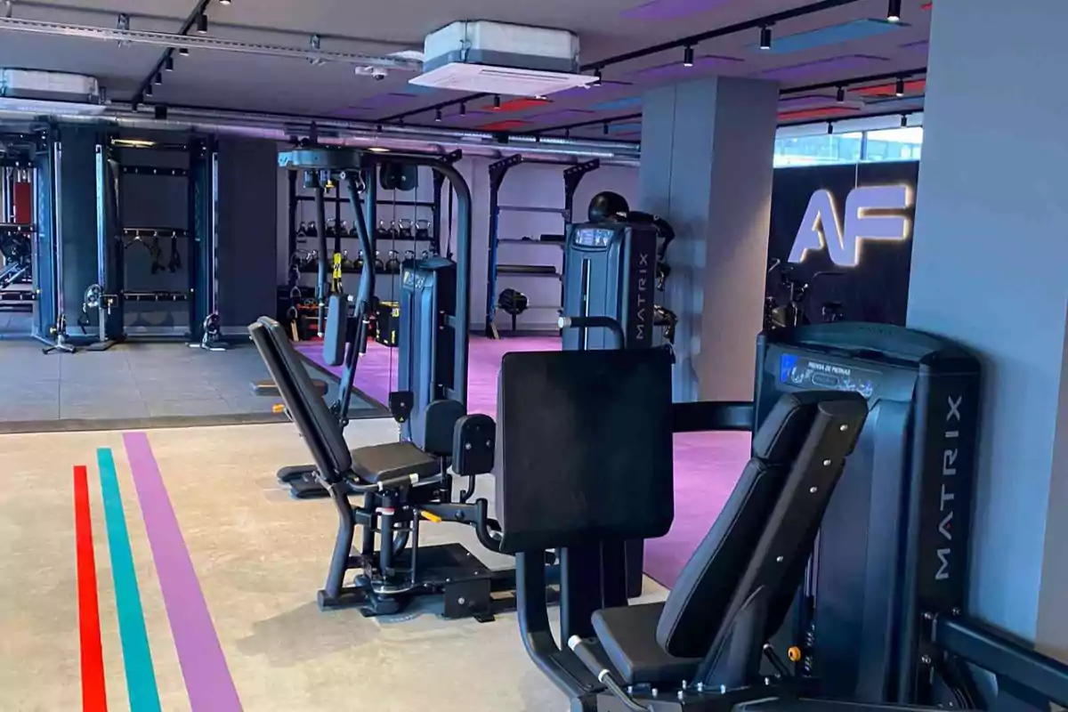 Gimnasio moderno con máquinas de ejercicio y un diseño interior colorido.