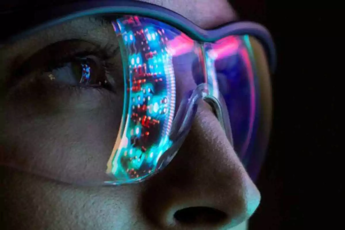 Primer plano de una persona usando gafas con reflejos de luces de colores en los cristales.
