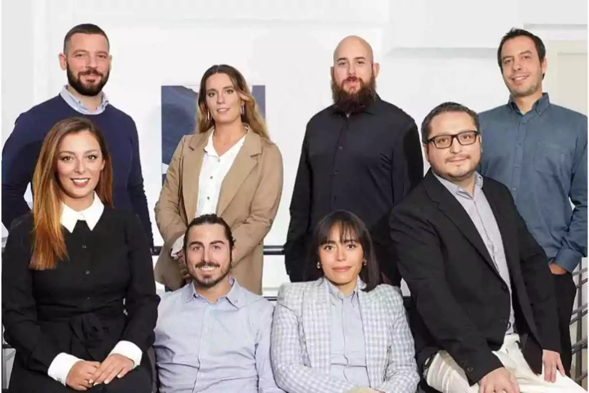 Un grupo de ocho personas posando juntas en un entorno profesional.