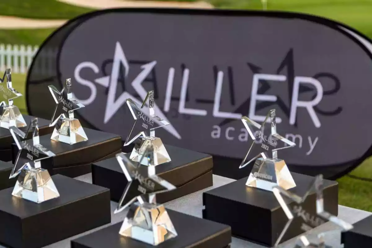 Trofeos en forma de estrella con la inscripción "Skiller 2023" sobre una mesa, con un cartel de fondo que dice "Skiller Academy".