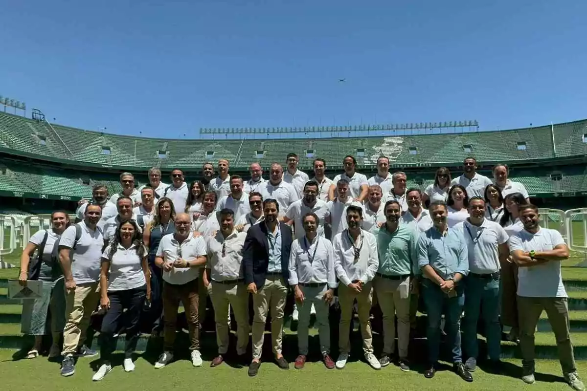 Un grupo de personas posando en un estadio de fútbol vacío.