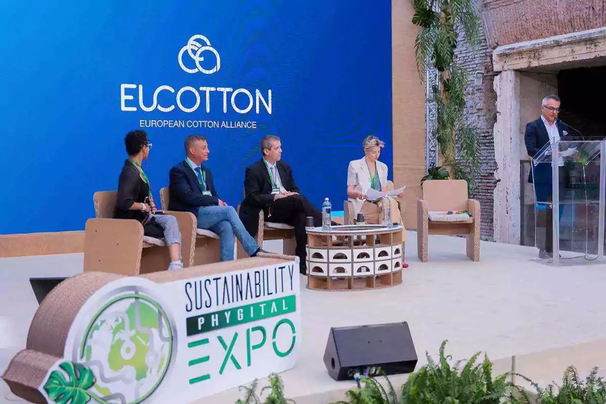 Panel de discusión en la Expo de Sostenibilidad Phygital con el logo de EUCOTTON en el fondo.