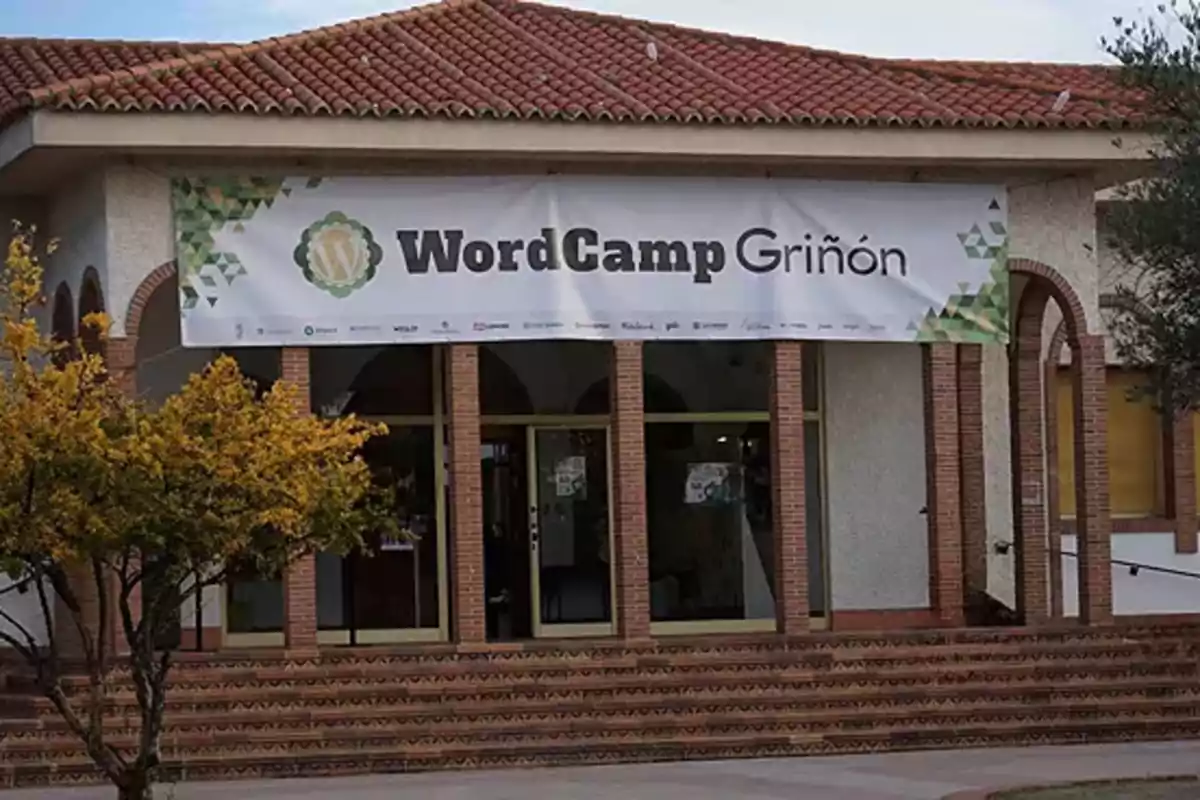 Fachada de un edificio con un cartel que dice "WordCamp Griñón".