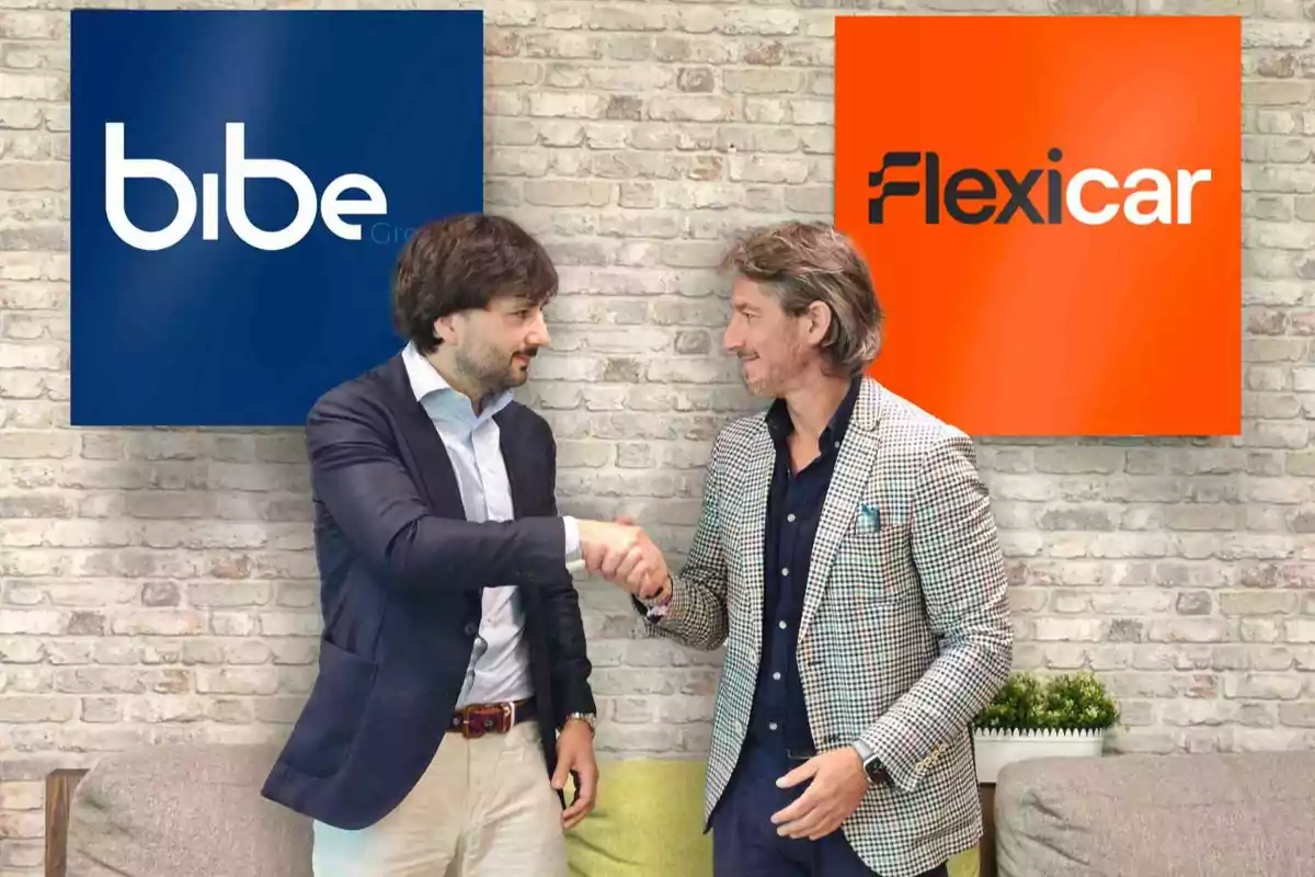 Dos hombres de negocios se dan la mano frente a los logotipos de Bibe y Flexicar sobre una pared de ladrillo