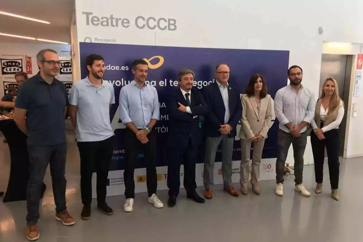 Un grupo de personas posando frente a un cartel en el Teatro CCCB.