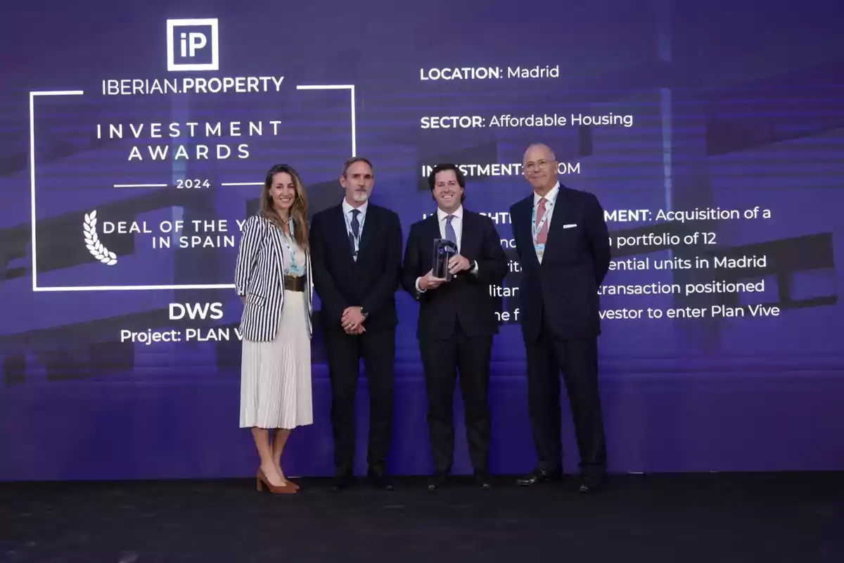 Cuatro personas posan en un escenario durante los Iberian Property Investment Awards 2024 en Madrid, donde se premió a DWS por el proyecto Plan Vive en la categoría de "Deal of the Year in Spain".