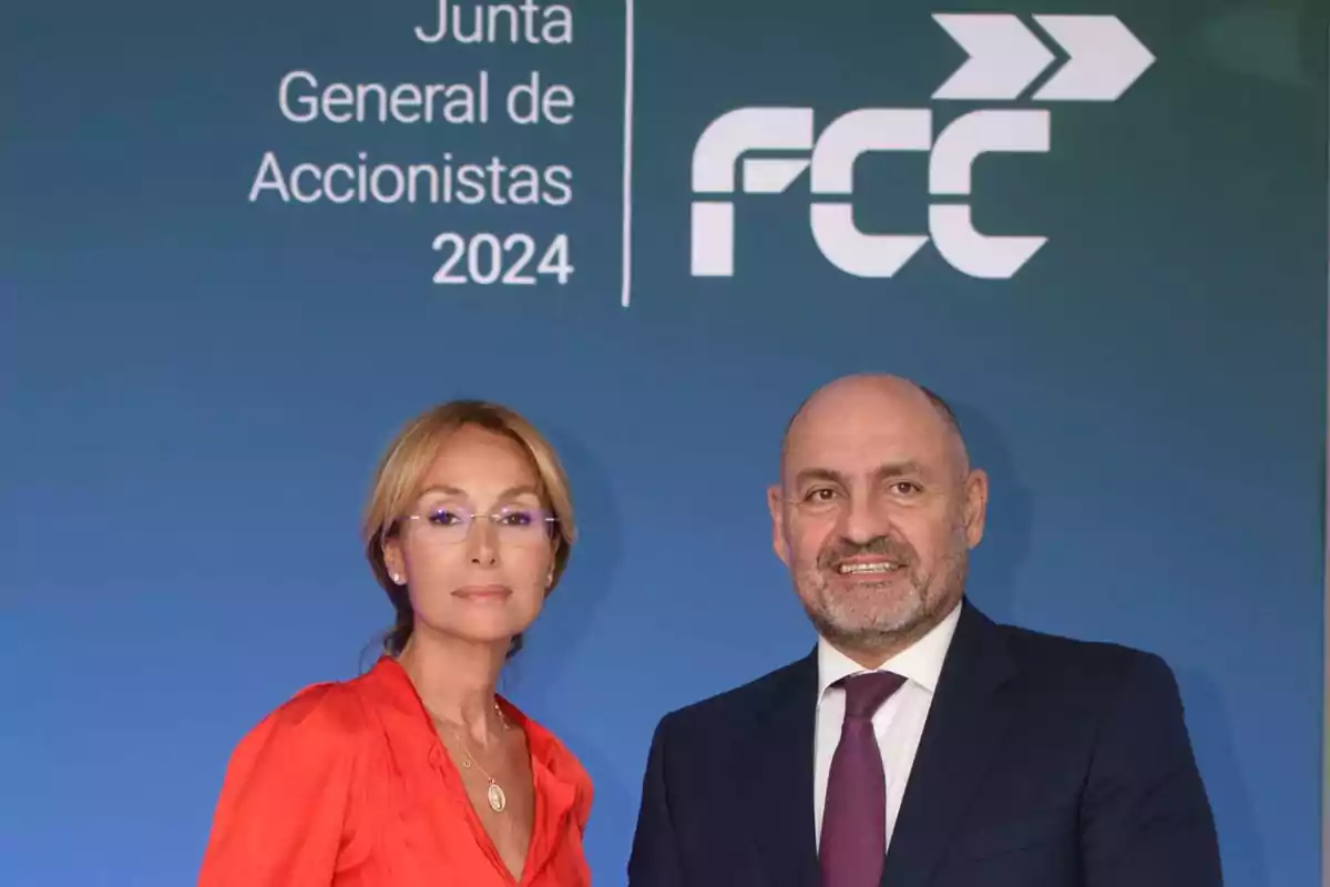 Dos personas posando frente a un cartel que dice "Junta General de Accionistas 2024" y el logotipo de FCC.