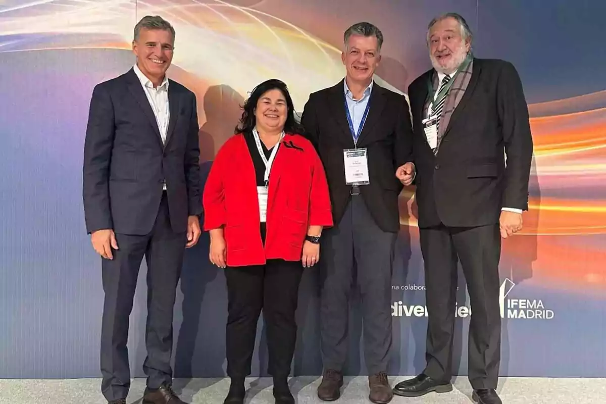 Cuatro personas posan juntas en un evento en IFEMA Madrid, dos hombres a cada lado y una mujer y un hombre en el centro, todos con etiquetas de identificación.