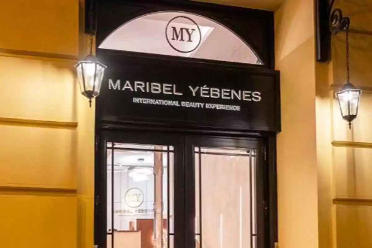 Entrada de un centro de belleza llamado "Maribel Yébenes" con el lema "International Beauty Experience" y el logotipo "MY" en la parte superior.