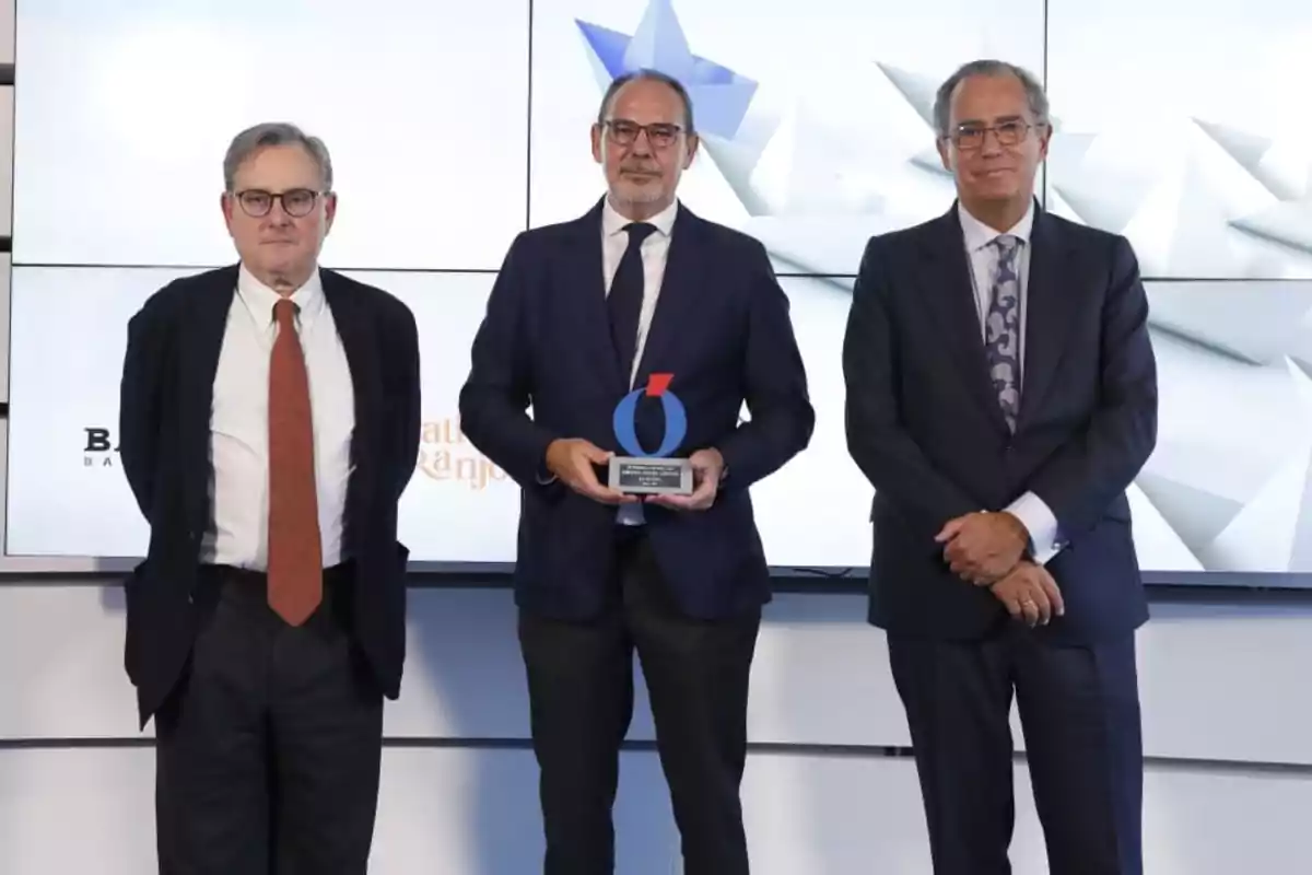 tres personas recibiendo un premio