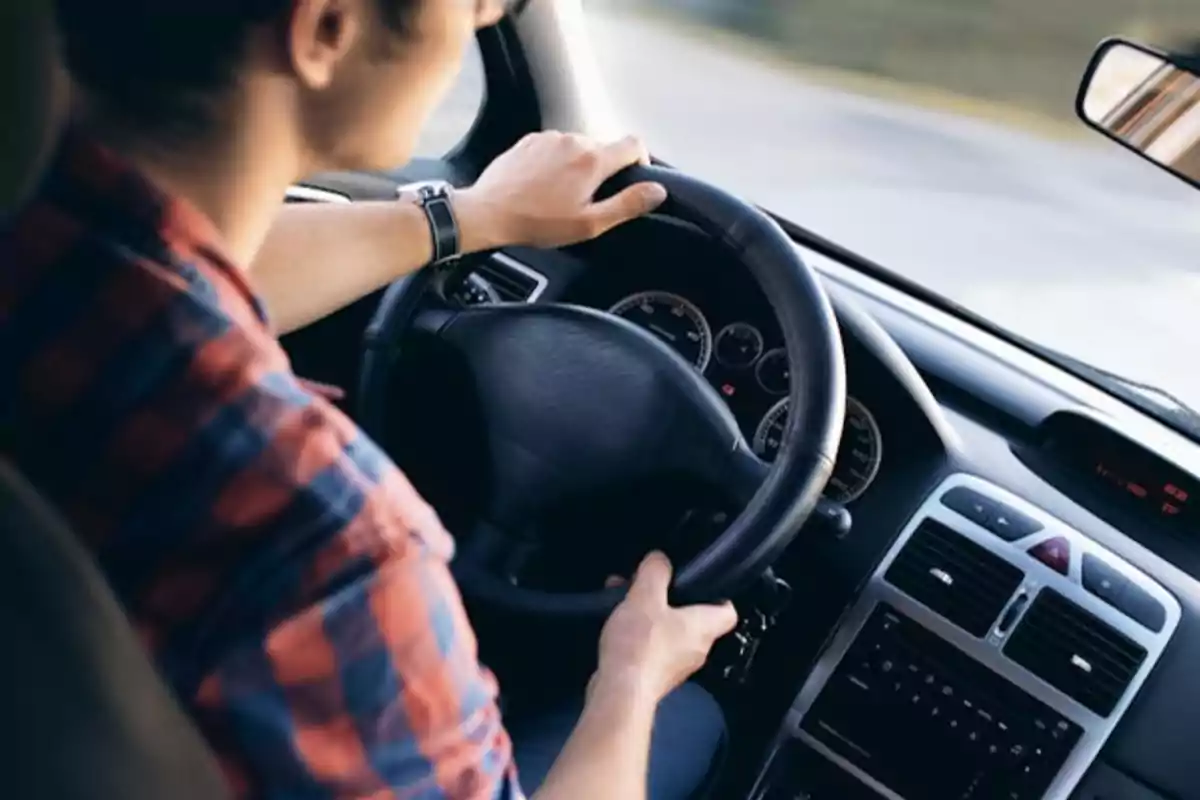 Persona conduciendo un automóvil, vista desde el asiento del pasajero.