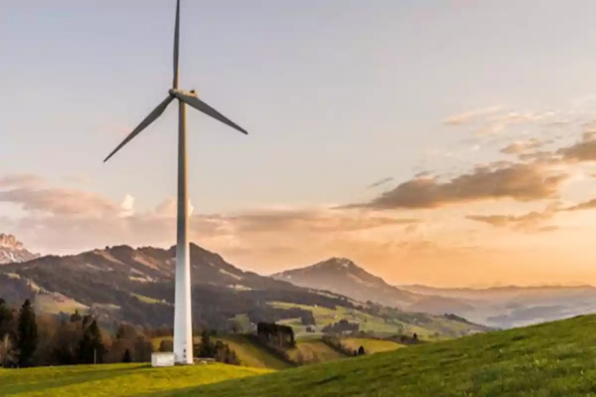 Molino de viento en un paisaje montañoso al atardecer.