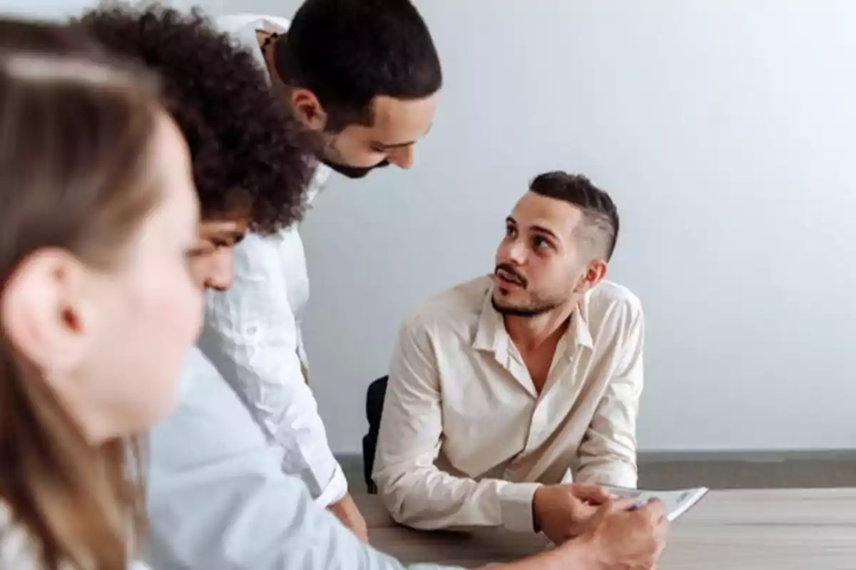 Personas en una reunión de trabajo discutiendo un documento.