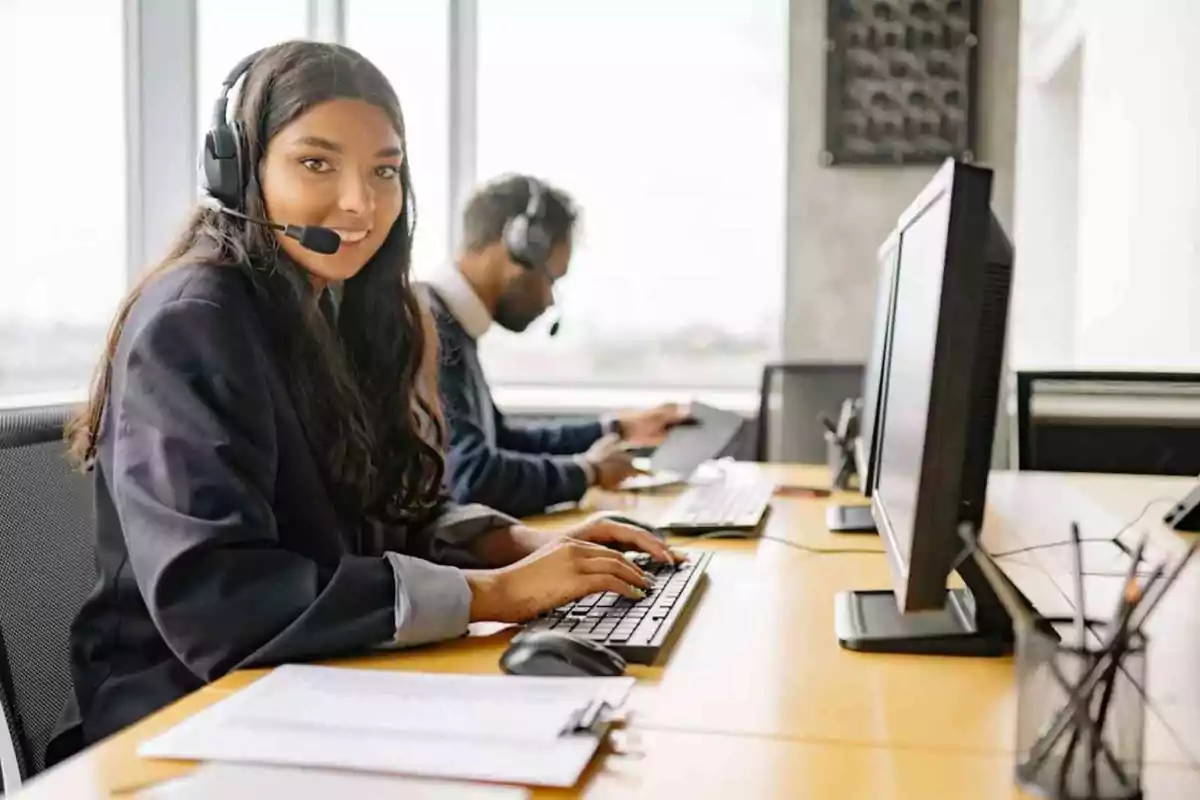 Personas trabajando en un centro de atención al cliente con auriculares y computadoras.