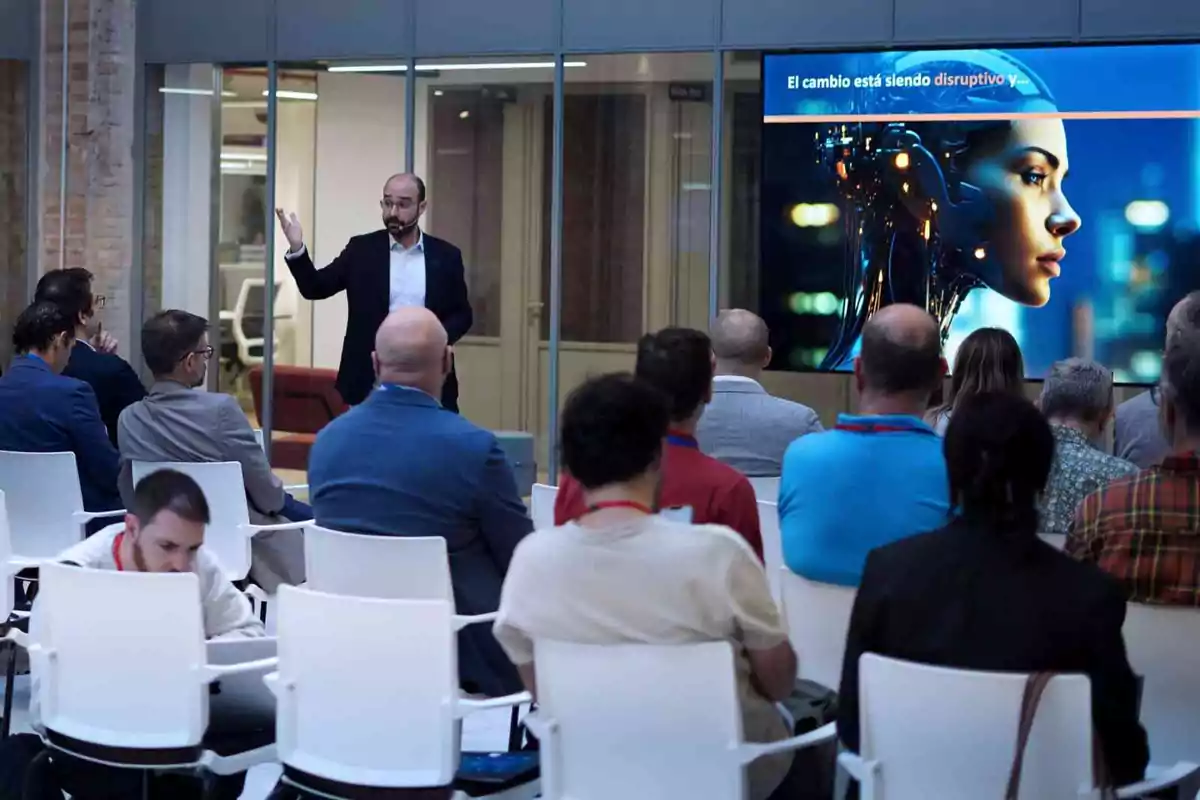 Un hombre da una presentación sobre tecnología a un grupo de personas en una sala de conferencias.