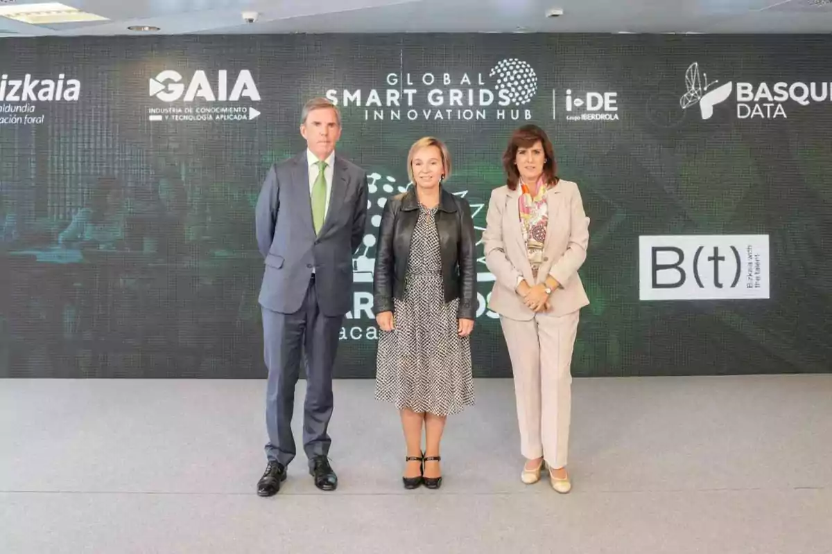 Tres personas posan frente a un fondo con logotipos de empresas y organizaciones relacionadas con innovación y tecnología.