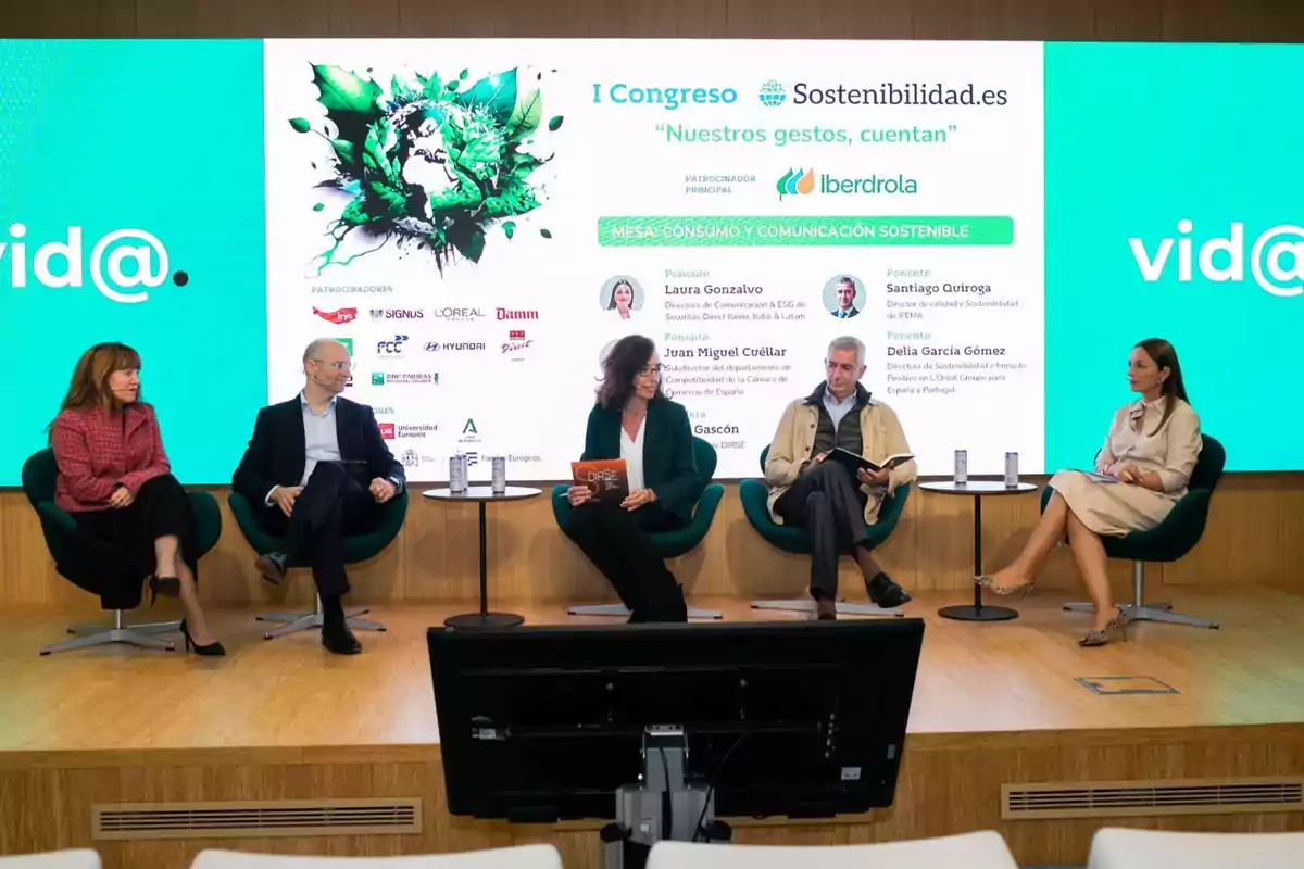 Cinco personas sentadas en un escenario participando en un panel de discusión sobre sostenibilidad, con una pantalla detrás que muestra información del evento y logotipos de patrocinadores.