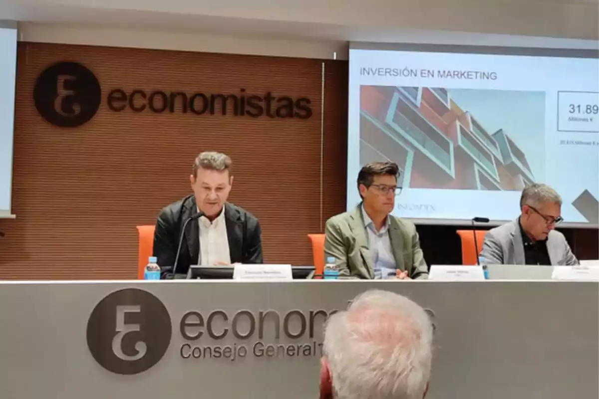 Tres personas sentadas en una mesa durante una conferencia sobre inversión en marketing en el Consejo General de Economistas.